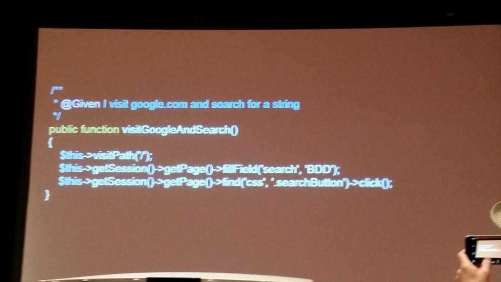 Photo of some Magento code projected on the big screen, specifically, the visitGoogleAndSearch() method.